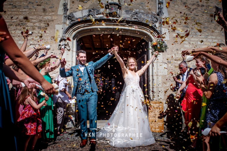 Claire et Corentin sortent de l'église sous une pluie de pétales de roses, un moment festif et magique.