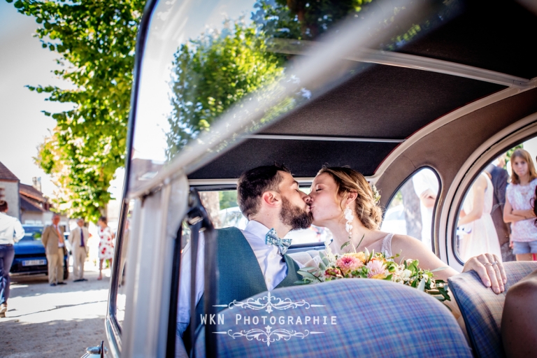 Claire et Corentin échangent un baiser tendre pour célébrer leur union après leur sortie de l'église.